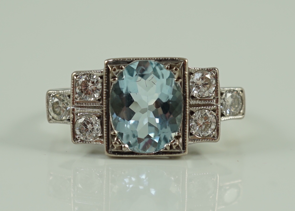 An 18ct white gold oval cut aquamarine and six stone diamond cluster set dress ring